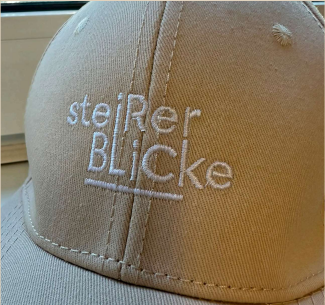 Embroidered beige cap from the REVEL production archive.